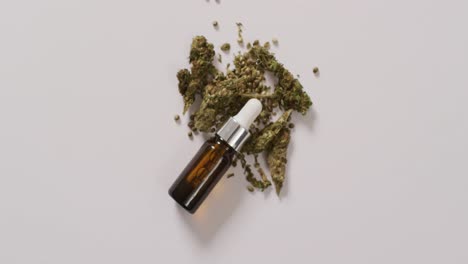 video of marijuana buds and bottle of cbd extract on white background