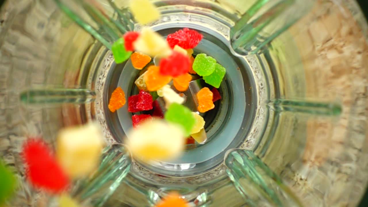 Falling of succade in a blender bowl. Slow motion. Top view