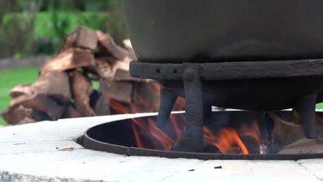 una antigua tetera de hierro sobre el fuego de una fogata al aire libre