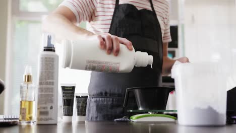 Mid-section-view-man-putting-hair-product-in-a-bowl