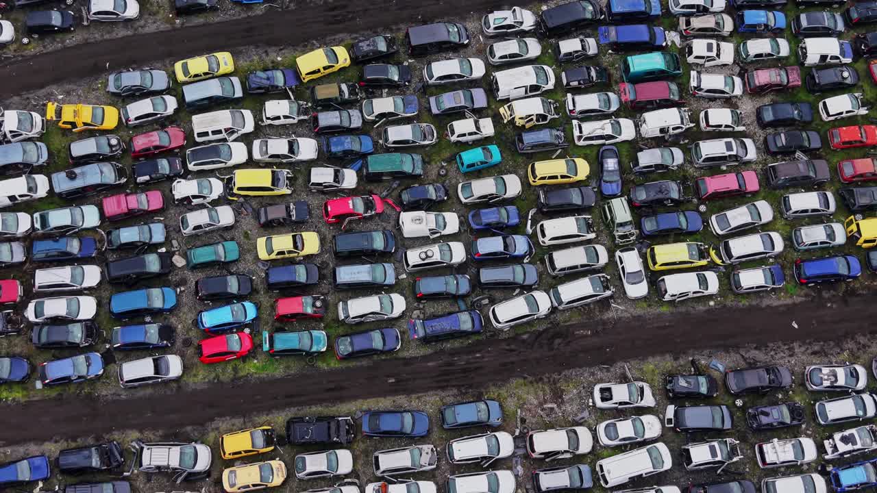 Autokerkhof fyldt med gamle biler arrangeret på rækker på et bilredningssted