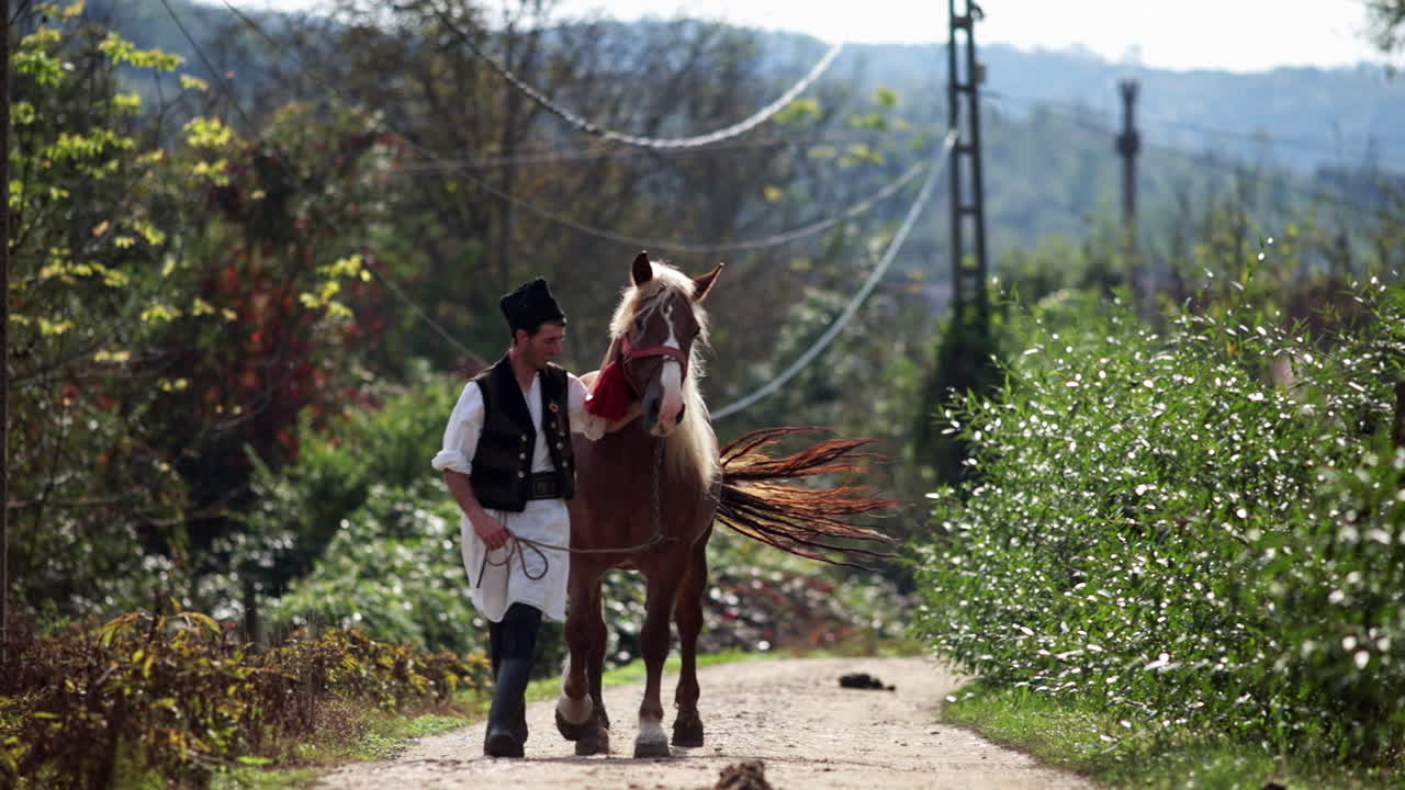 rumano en traje tradicional camina junto al caballo 2