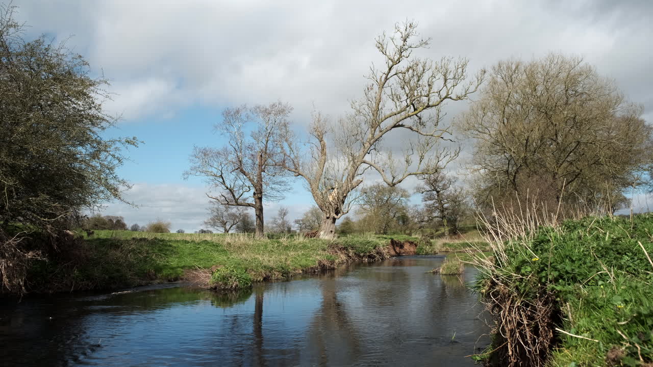 un día soleado y ventoso en la flecha del río en warwickshire, inglaterra, mientras las nubes pasan por encima de la cabeza