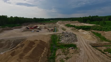 Aerial-backwards-shot-of-industrial-sand-quarry-during-sunny-day-in-Latvia