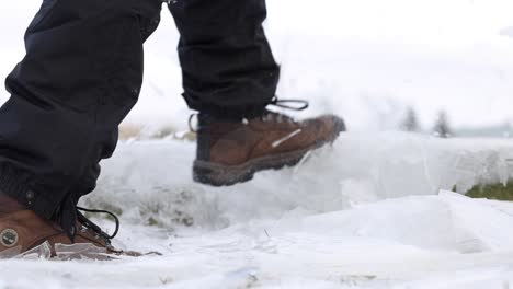 hiking boots smashing through thin layers of ice super slomo