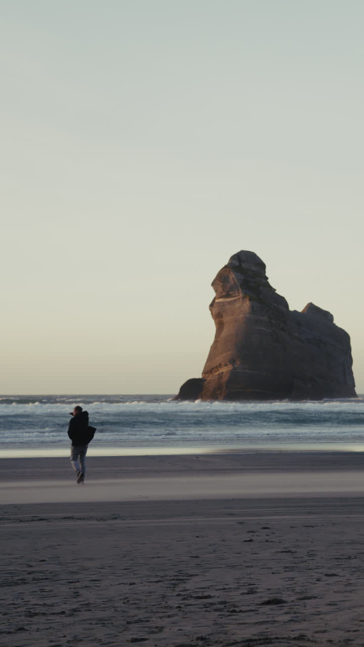 해가 지면 해변을 고 있는 남자