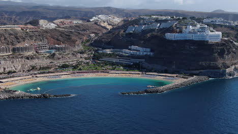 aerial view in orbit over amadores beach and the resorts near the coast