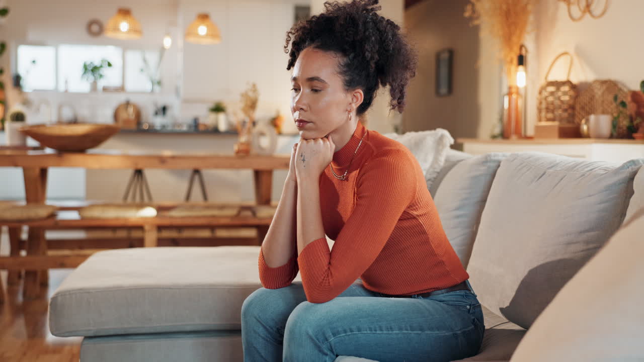 Woman Sitting Thoughtfully on a Sofa