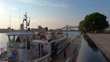 tourists on deck of river shuttle vessel docked, montreal port