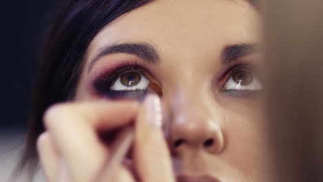 process of creating flawless make up look. applying eyeshadows in the inner corner. gorgeous brunette girl with hazelnut eyes.