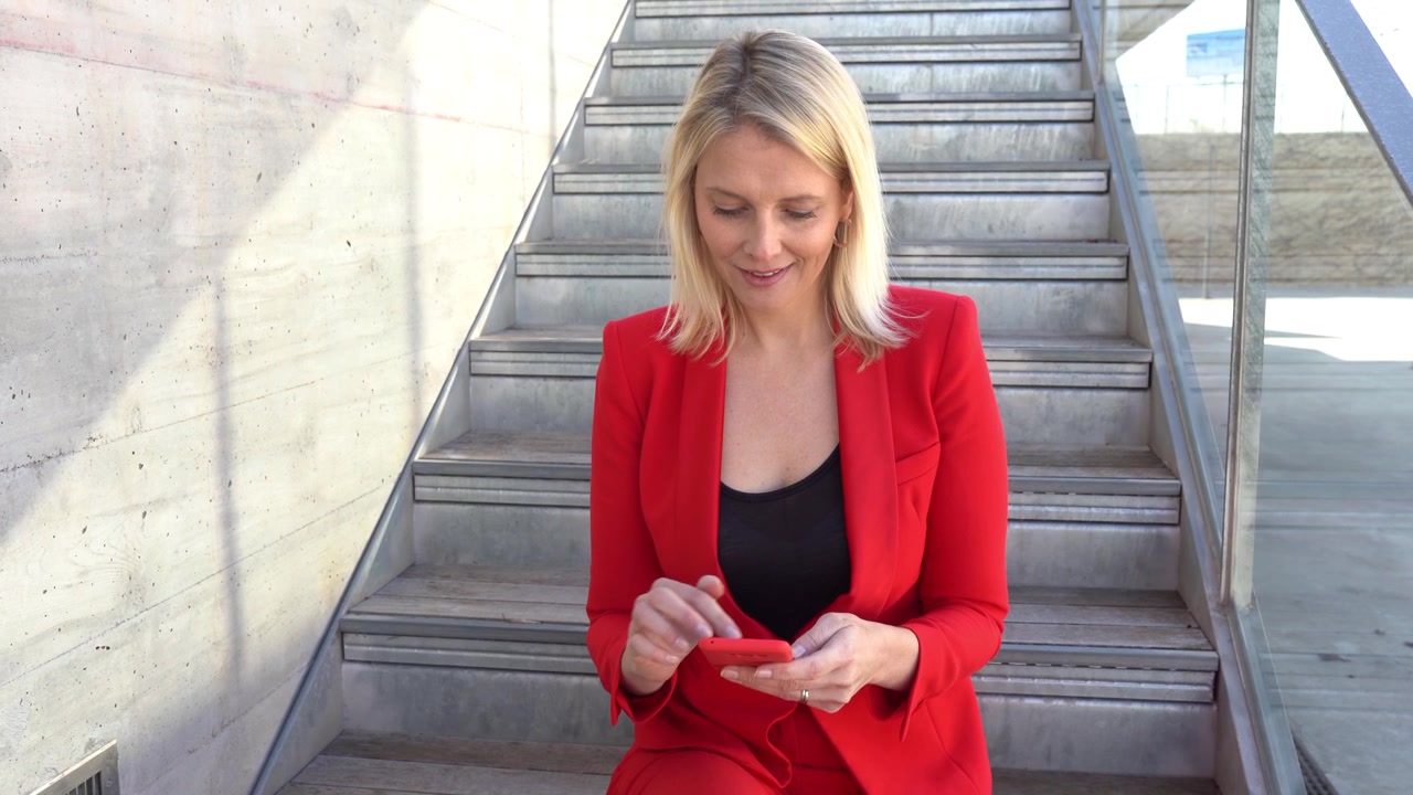 Donna d'affari di mezza età che usa lo smartphone all'aperto.