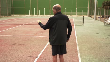 aged tennis player bouncing ball on racket