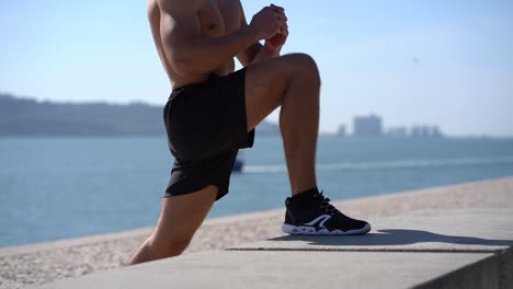 muscular young man training at riverside