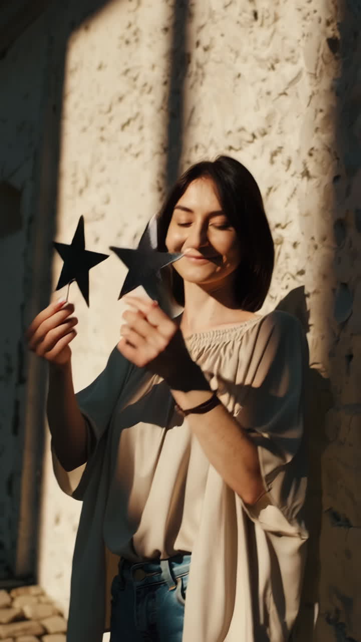 Una giovane donna tiene una stella alla luce del sole, esprimendo gioia e creatività