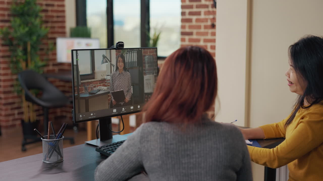 Coworkers using remote video call for job interview with applicant