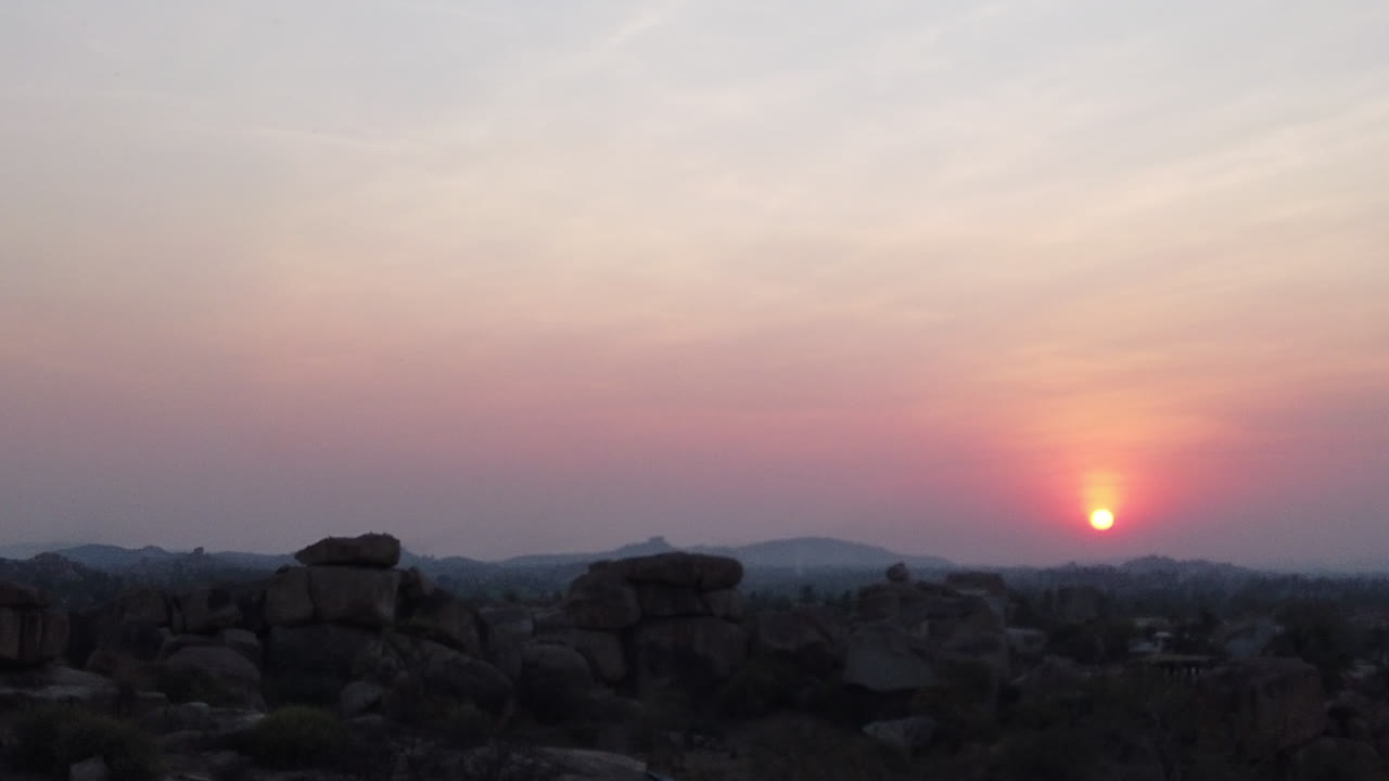 hiperlapso de puesta de sol sobre hampi acercándose al lugar donde se pone el sol y luego se desplaza hacia la derecha