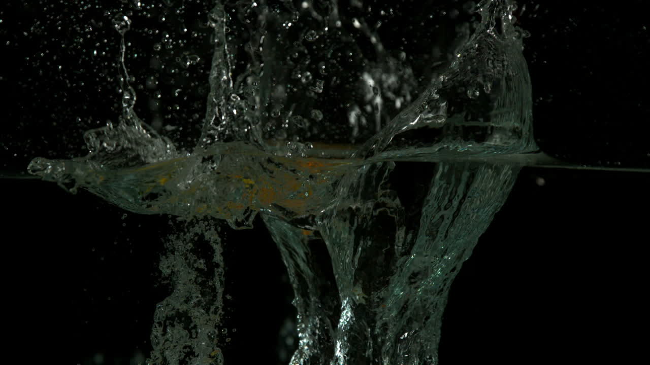 Lemon orange and lime plunging into water on black background