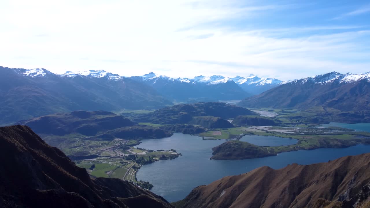 Drone view of lake and snow covered mountains on a sunny summer day at Roy's Peak, Wanaka, New Zealand.