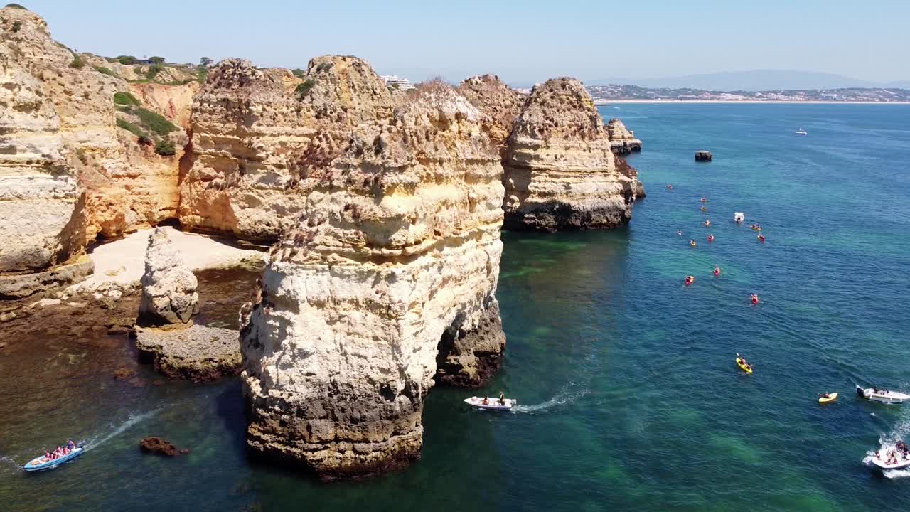 ponta da piedade, lagos, algarve - 보트, 카약, 바위 절벽, 아름다운 해안선 및 맑고 푸른 바다가 있는 공중 드론 보기