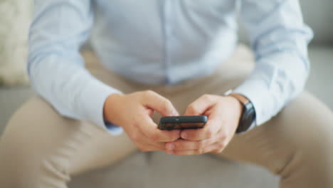 close up of man texting on smartphone