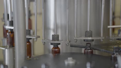 syrup bottles getting filled with liquid medicine in automatic machine.