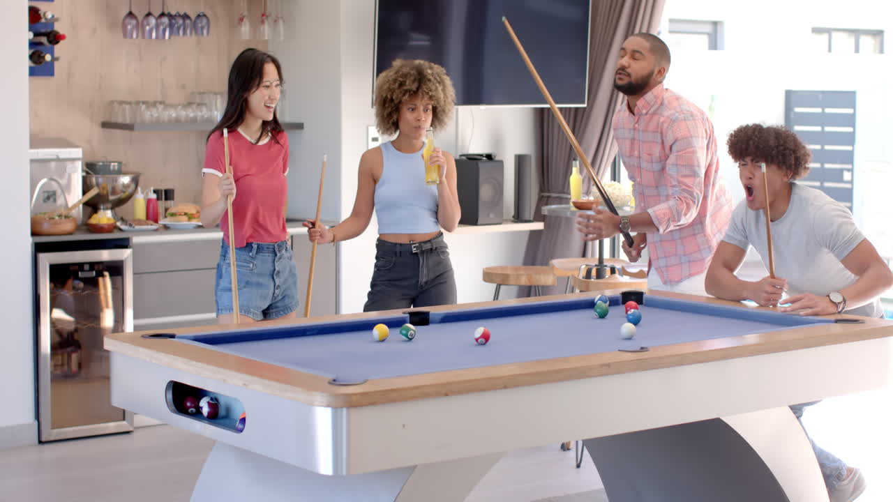 Playing pool and enjoying drinks, Diverse friends hanging out in modern living room