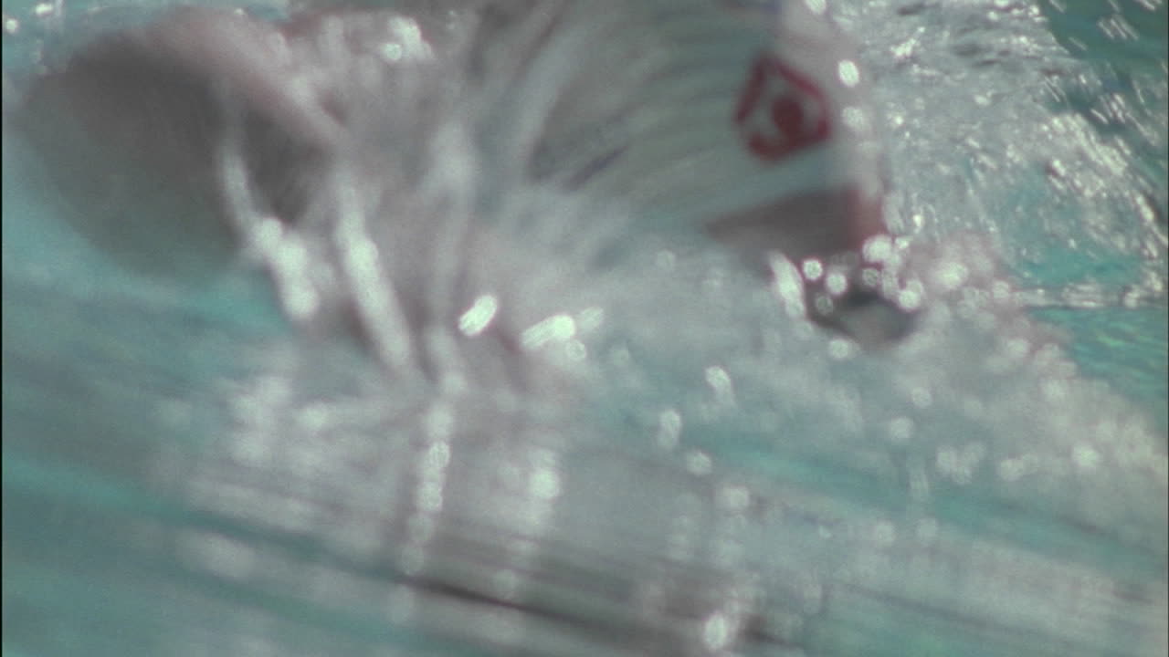 한 사람이 수영하면서 많은 물을 튀기고 있습니다.