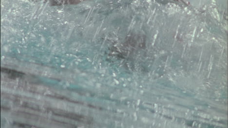 una persona está salpicando mucha agua mientras nada