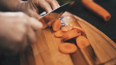 chopping carrots on wooden board in slow motion