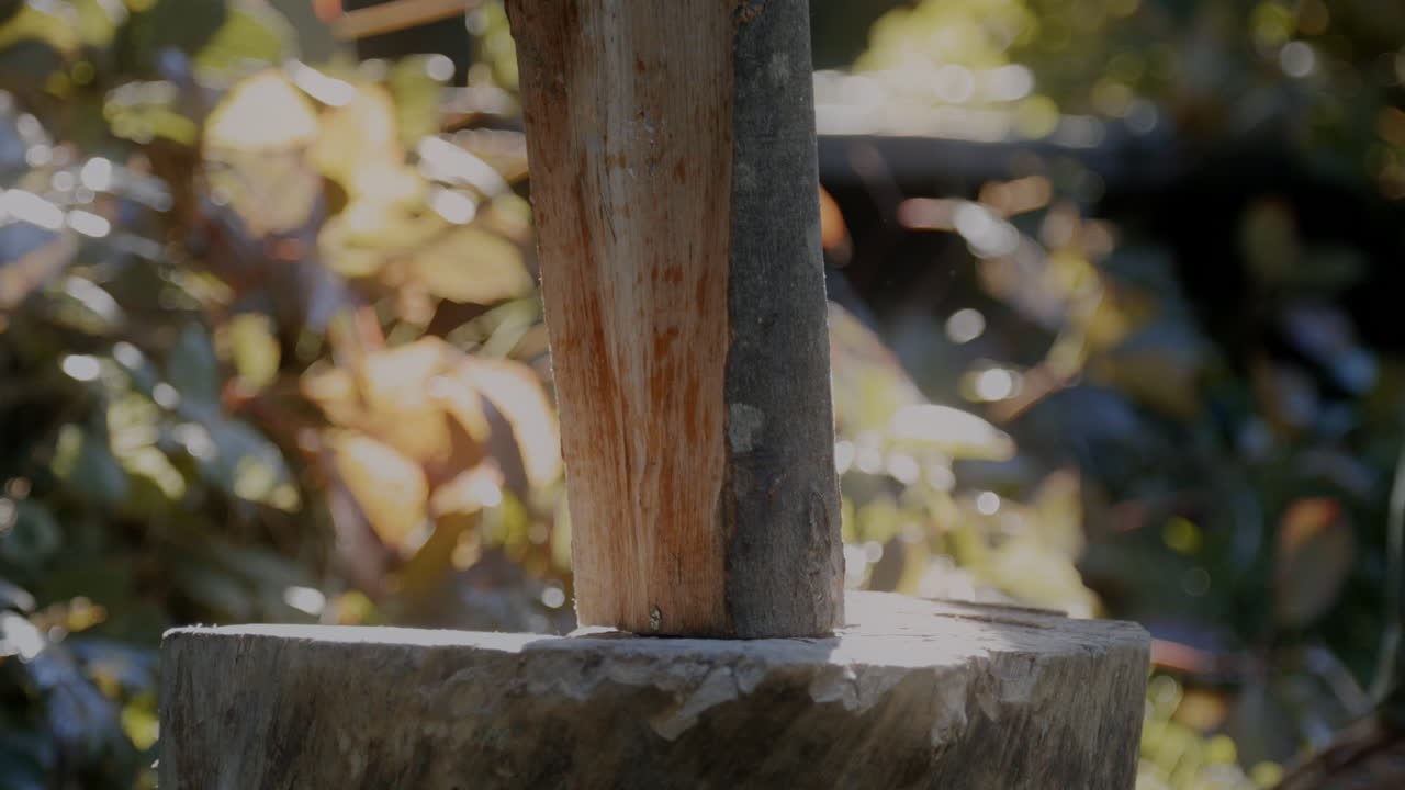 A man picks up wooden logs