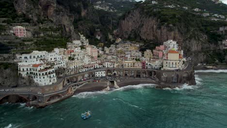 epic aerial view of amalfi town in southern italy, black sand beach in coast of tyrrhenian sea