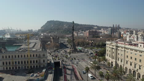 Vorwärts-Fliegen-über-Stark-Befahrene-Straßen-In-Der-Stadt.-Hohe-Säule-Mit-Statue-Auf-Der-Spitze-In-Der-Mitte-Des-Kreisverkehrs.-Barcelona,-Spanien