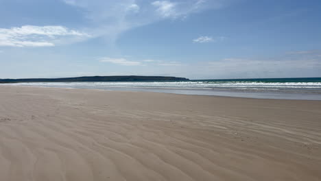 wide shot panning around an empty beach on the island of islay, on a bright sunny day