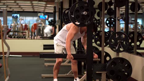 bodybuilder adjusting barbell weight safety support for squats