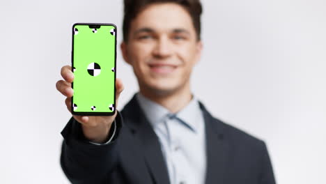 businessman holding smartphone with green screen