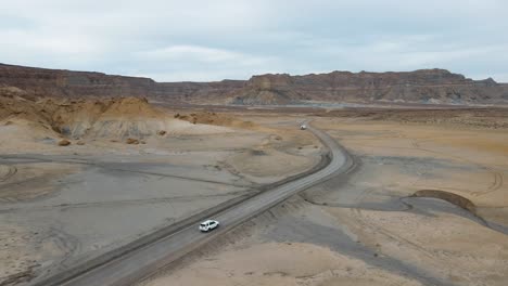 Drone-flies-over-a-car-driving-thru-Smoky-Mountain-towards-Alstrom-Point,-Lake-Powell