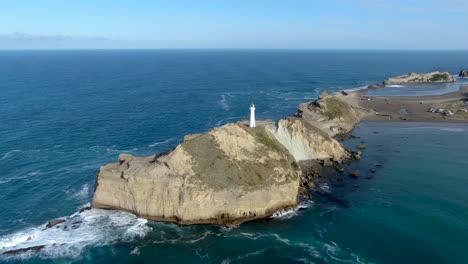 castlepoint lighthouse tower on north island of new zealand - aerial drone pullback