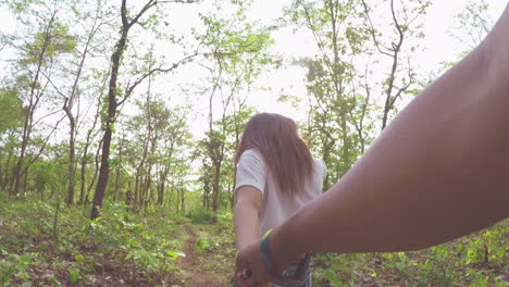 pareja tomados de la mano y caminando en el bosque