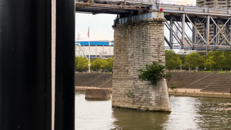 crucero por el río ohio bajo el puente purple people cerca del parque serpentine wall en newport, kentucky, estados unidos