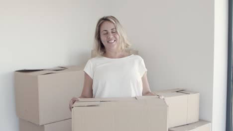 alegre mujer de mediana edad posando en su nuevo apartamento