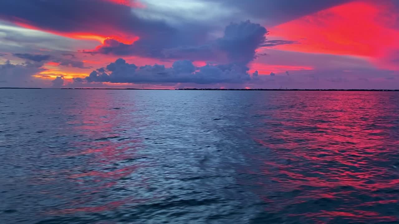 clip revelador de los colores rojos del horizonte en la puesta de sol sobre el océano en los cayos de florida, ee.uu.