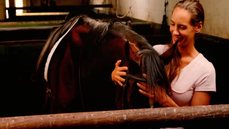 woman stroking horse in stable 4k