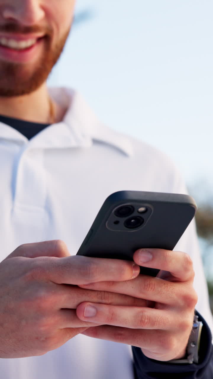 Giovane sorridente mentre usa lo smartphone all'aperto