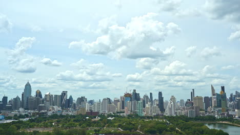 time-lapse of fantastic fast clouds moving over the modern bangkok cityscape, benjakitti park and lake in front daytime