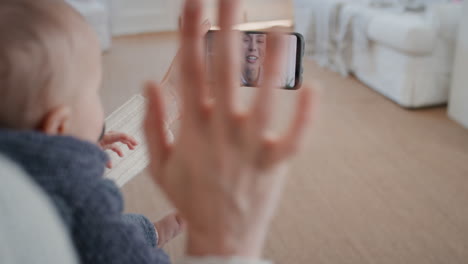 mother and baby using smartphone having video chat with best friend waving at toddler happy mom enjoying sharing motherhood lifestyle on mobile phone screen