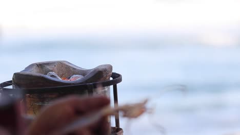 igniting charcoal in a grill by the sea