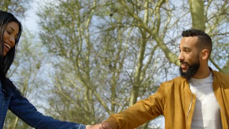 Low-angle-view-of-happy-young-mixed-race-couple-holding-hands-in-the-city-4k