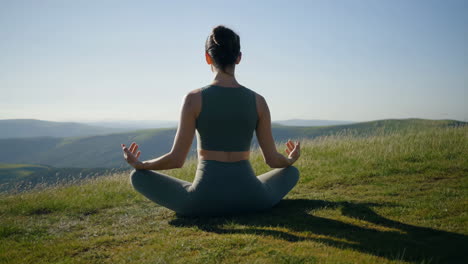 woman meditating in nature on a mountain top