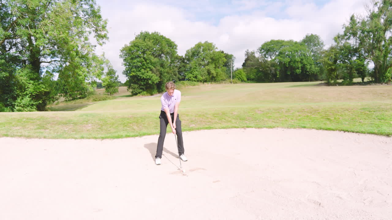 Male golf player playing golf and knocking golf ball out on golf course, copy space