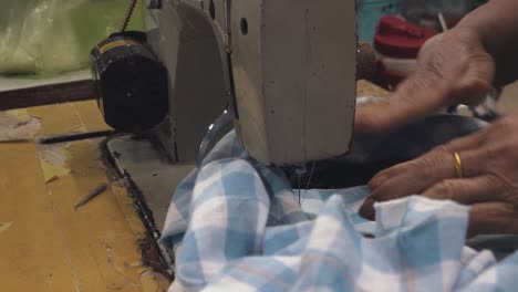 una costurera usando una máquina de coser en el mercado